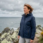 Femme en randonnée sur les falaises de granit de la côte bretonne avec vue sur l'Atlantique